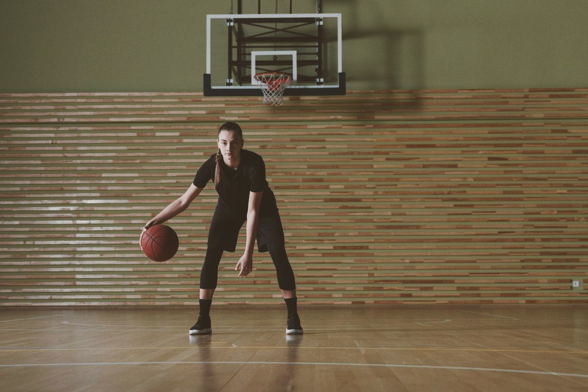 A basketball player in action on an indoor court, ball in hand