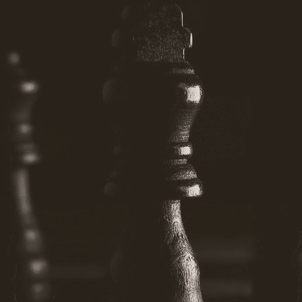 A chessboard with pieces mid-game, the king in focus