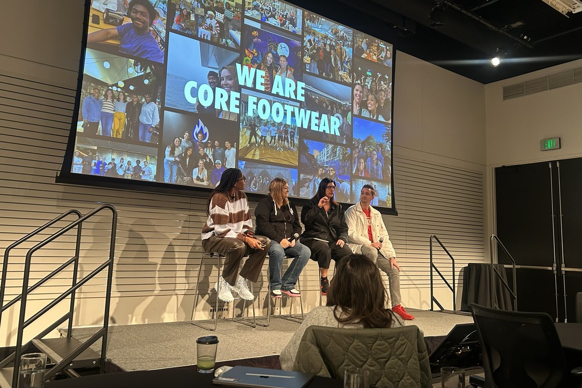 Michelle Snow on stage with a panel during the Core Footwear meeting, room watching