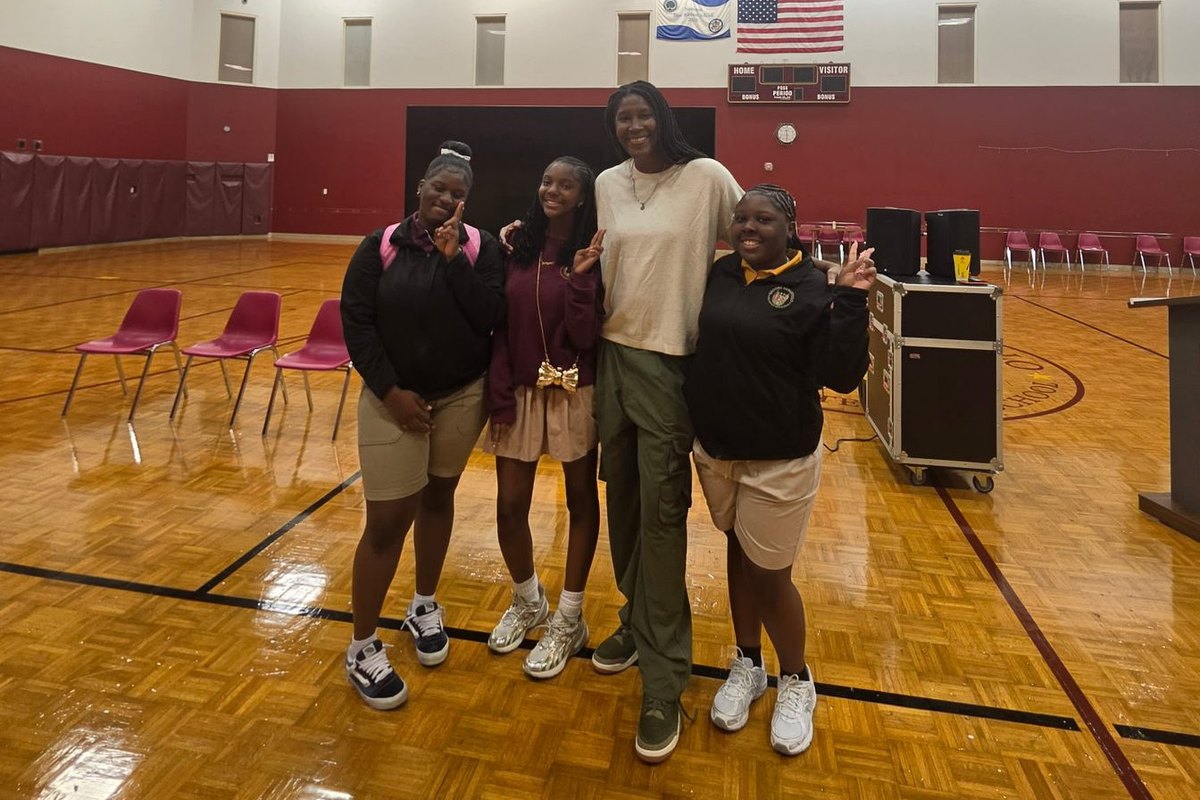 Michelle Snow with three students on a school gym court